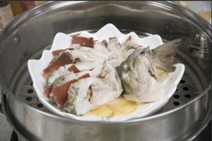 將鱸魚成花狀擺好，將火腿切片放入各縫隙中，放入鍋中隔水蒸12分鐘拿出，撒上蔥花即可。