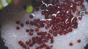 將炒好的食材和大米、紅豆一起放進(jìn)電飯鍋煮。