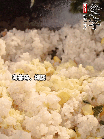 剩米飯下鍋炒散，依次下玉米粒、雞蛋、烤腸、海苔碎翻炒均勻。