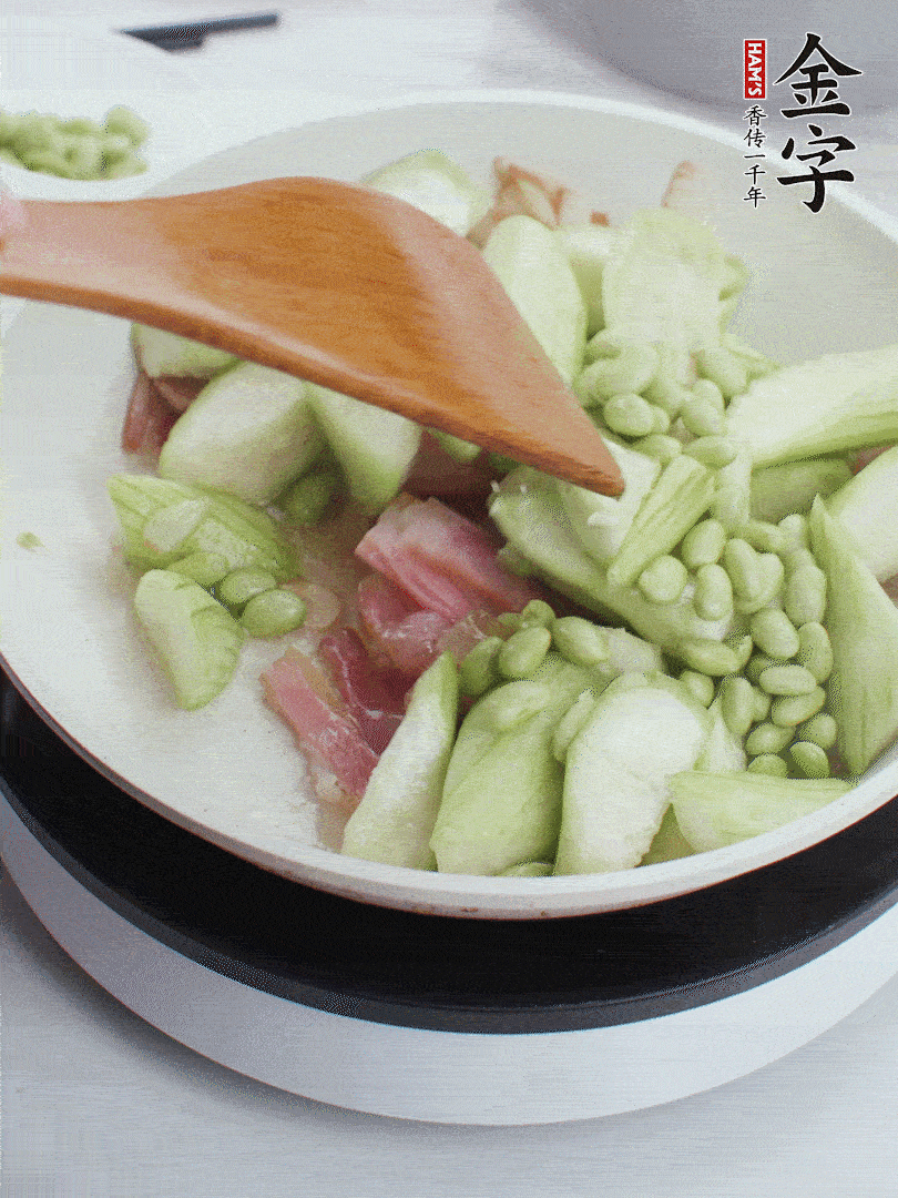 依次下絲瓜、青豆翻炒，炒至絲瓜打蔫縮小。