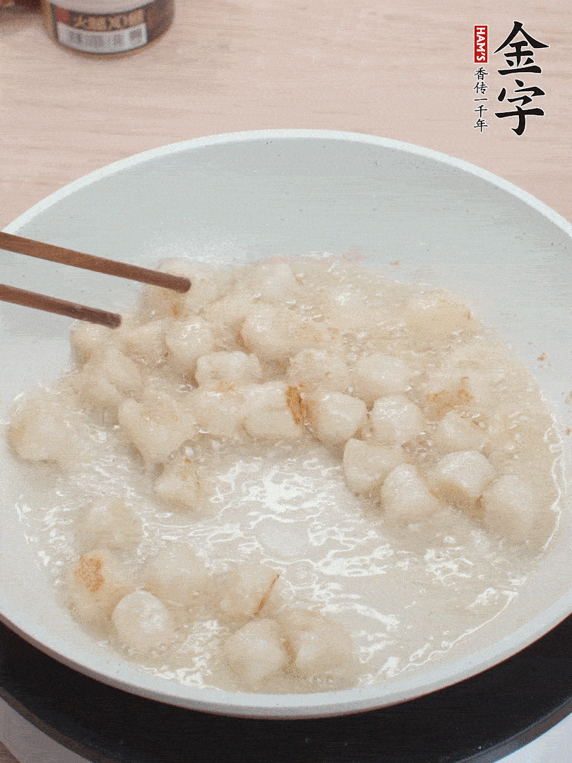 油溫4成熱，鮮貝蘸干淀粉下鍋煎，一面微黃后翻面。