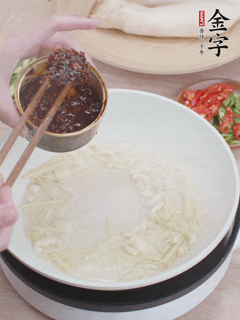 起鍋熱油，姜蒜、金字火腿干貝醬煸香。