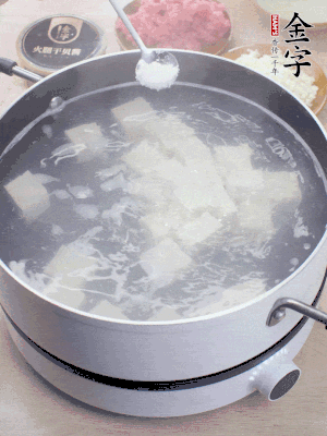 豆腐切成大小均勻正方體，鍋內(nèi)放水，加一點鹽焯水10秒。