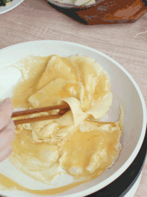 油6成熱時，下雞蛋液，邊緣凝固時翻拌成塊狀。