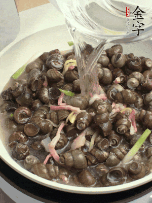 倒處理干凈的螺螄翻炒，加3勺料酒。加清水蓋過螺螄，中火蓋蓋煮5分鐘。