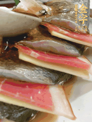 魚肚中塞蔥結(jié)、火腿片，魚身上碼放姜片、火腿片，倒入混合的料汁。