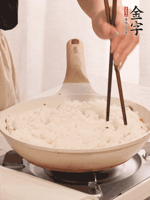 把瀝干水分的米飯均勻鋪在上面，筷子戳幾個洞，以便透氣，轉(zhuǎn)小火蓋上蓋子燜至水分收干，大概10分鐘。
